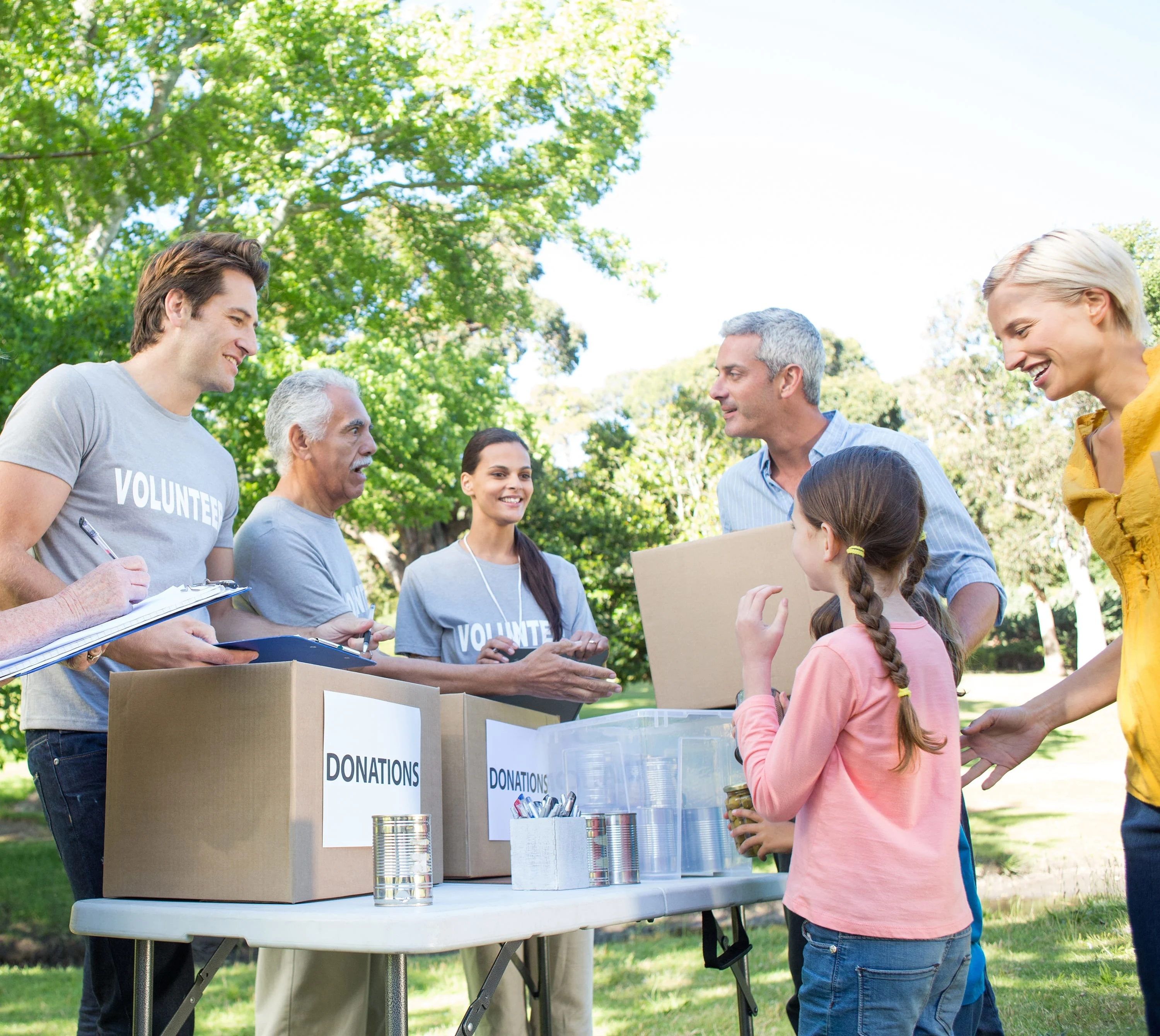 Happy volunteer family separating donations stuffs on a sunny day
