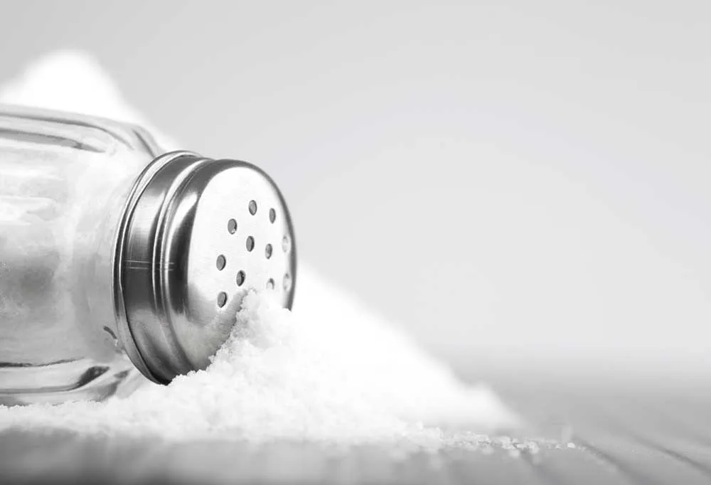 black and white photo of a Salt shaker spilled over 