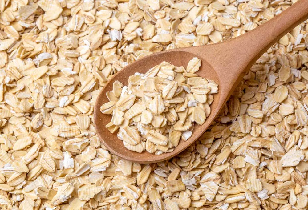 Close up of raw oats with a wooden spoon