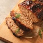 Sliced meatloaf on a wooden cutting board