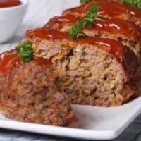 Close up of sliced meatloaf on a white plate