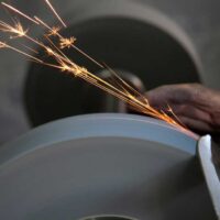 Person sharpening a knife on a grinding wheel